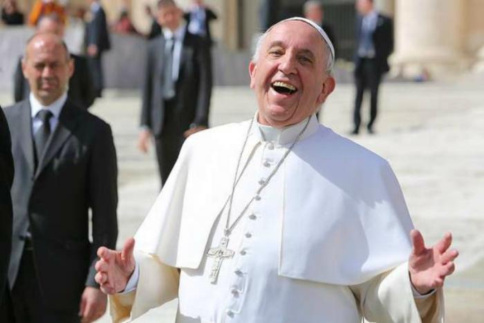 Pope Francis laughing outside of St. Peter's Basilica.